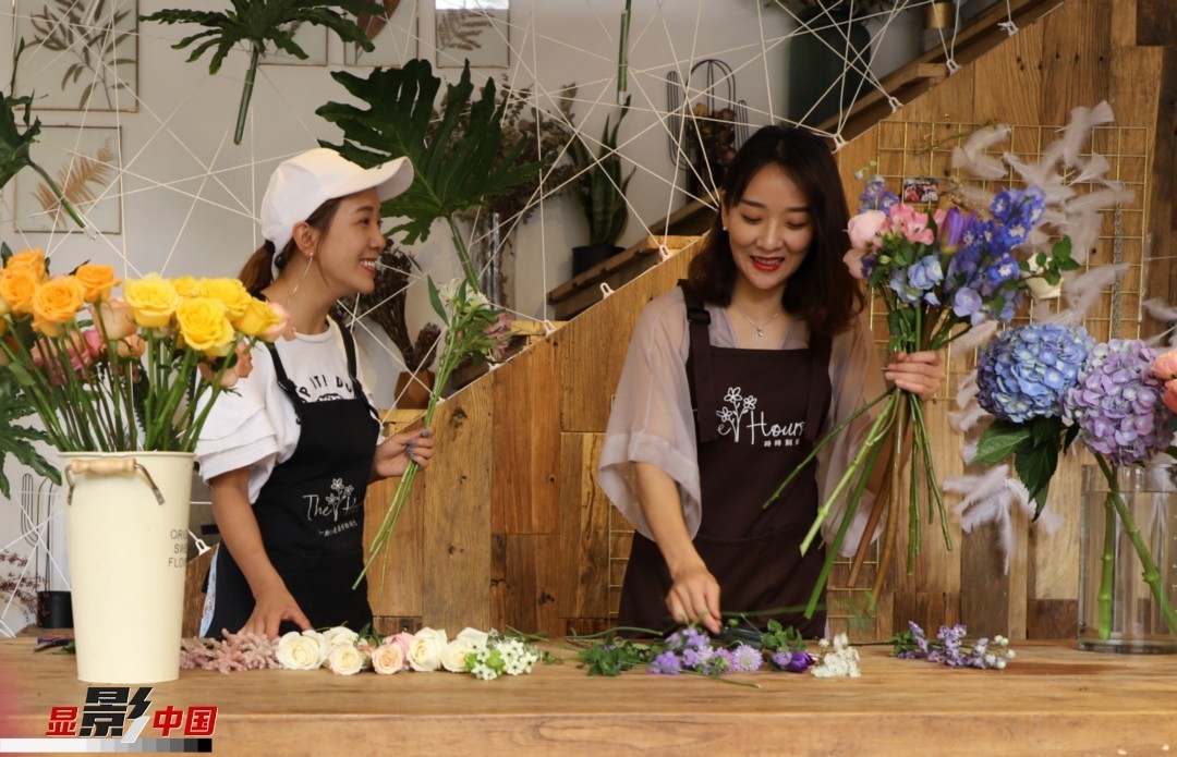 “昆明是鮮花的原產(chǎn)地，有亞洲最大的鮮切花交易市場(chǎng)，可以說(shuō)具備開(kāi)花店的天時(shí)地利；另外和很多女孩一樣，我從小也就有開(kāi)花店的夢(mèng)想！”說(shuō)起當(dāng)初的決定，王黎媛說(shuō)一是因?yàn)閴?mèng)想，另外也跟昆明這個(gè)城市產(chǎn)花、賣(mài)花的“基因”有關(guān)。圖為王黎媛和同事在制作花束。新華網(wǎng) 周亞平/攝 念新洪/文